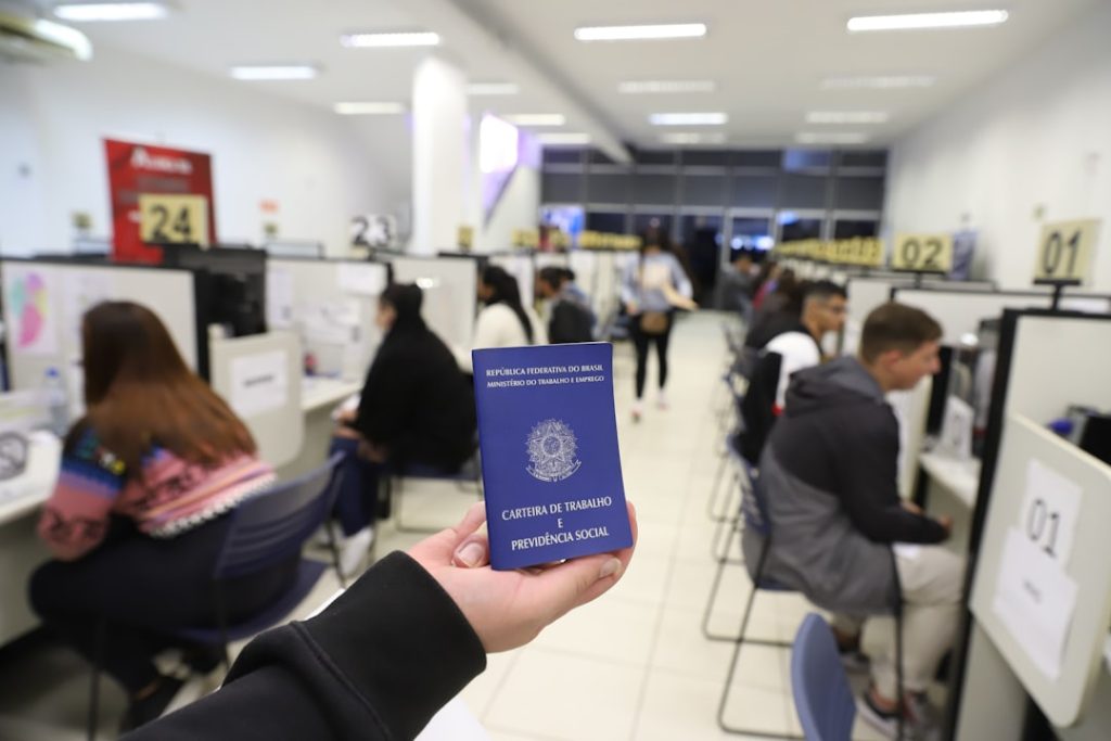 a-person-holding-up-a-blue-passport-in-an-office-ivl2fodrmbi